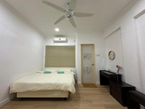 a bedroom with a bed and a ceiling fan at MUJI’Homestay Bukit Tinggi in Bentong