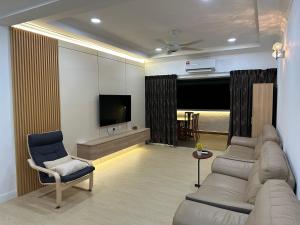 a living room with a couch and a tv at MUJI’Homestay Bukit Tinggi in Bentong