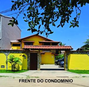 a yellow house with a garage at Uma PAUSA na sua vida, com: sol, praia e sossego! in Cabo Frio