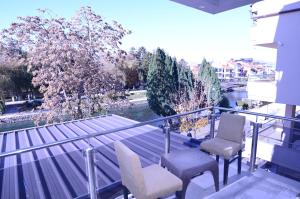 a balcony with two chairs and a view of a river at Hotel New York Struga in Struga