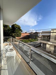 - un balcon avec des tables et des chaises dans un bâtiment dans l'établissement El samán, à Cartago