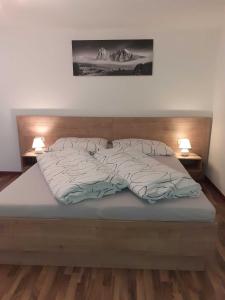 łóżko w sypialni z dwoma lampami po obu stronach w obiekcie Appartement Spiss w mieście Ried im Oberinntal
