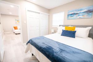 a bedroom with a large bed with blue and yellow pillows at UNIVERSITY SERENITY SUITES in Tampa