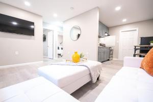 a white living room with two white couches at UNIVERSITY SERENITY SUITES in Tampa