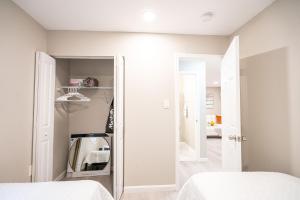 a bedroom with two beds and a closet at UNIVERSITY SERENITY SUITES in Tampa