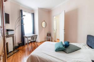 Un dormitorio con una cama con almohadas azules. en Merveille des Chartrons, en Burdeos