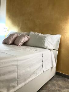 un letto bianco con due cuscini sopra di Appartamento di Giò a Palermo