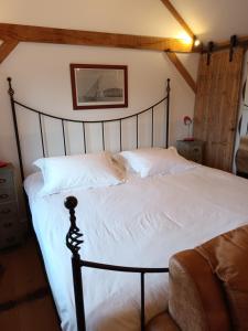 a bedroom with a large bed with white sheets at The Music Room - Kingsize Double Oak Studio - Sleeps 2 - Quirky - Rural in Haslemere