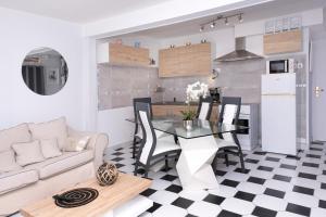 een keuken en een woonkamer met een tafel en een bank bij L'Ambre - Appt au cœur de la Normandie in Brionne
