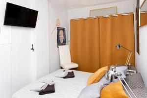 een slaapkamer met een bed met een televisie en een bed sidx sidx sidx bij L'Ambre - Appt au cœur de la Normandie in Brionne
