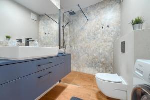 a bathroom with a sink and a toilet at Apartament Figo in Szczecin