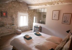 a bedroom with a large bed with towels on it at La Maison de Marguerite in Montbrun-les-Bains