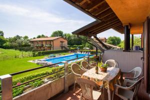 a patio with a table and chairs and a pool at Residenza Corte Casara in Lazise