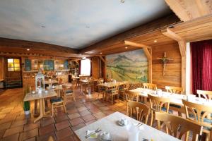 a restaurant with tables and chairs and a mural at Hotel-Gasthof Hirschen in Blumberg