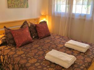 a bed with two white towels on top of it at B&B Mina Clavero in Mina Clavero