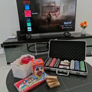 a table with a laptop on a table in front of a tv at THE COVE at D'Garden City Centre in Batu Pahat