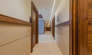 a hallway of a hospital with wooden doors and a hallwayngth at Treebo Trend Tiba in Bangalore
