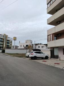 two cars parked in a parking lot next to a building at Studio 10 in Mamaia Sat/Năvodari