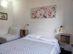 a bedroom with a white bed and a chair at Albergo Caffaro in Genoa