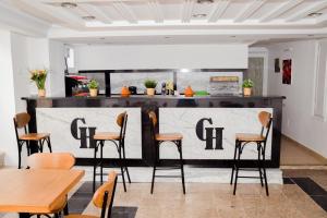 a restaurant with a bar with chairs and tables at Le Grand Hotel Djerba in Houmt Souk