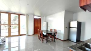 a kitchen with a table and chairs and a refrigerator at Modern Master bedroom B in Nadi