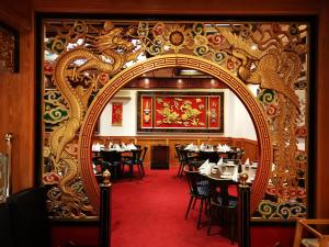 una puerta ornamentada a un comedor con mesas en China Restaurant Hotel Lotus, en Rothenburg ob der Tauber