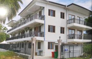 a white apartment building with balconies and a fence at Modern Master bedroom B in Nadi