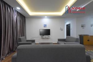 a waiting room with couches and a flat screen tv at Noble Vivacity Jazz 2 Cozy Homestay in Kuching