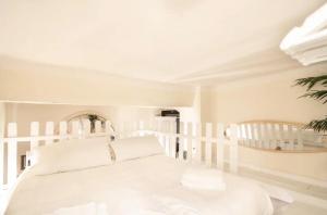- une chambre blanche avec un lit blanc et une chaise dans l'établissement [Lovely Suite] Piazza delle Erbe, à Vérone