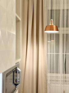 a bathroom with a shower curtain and a lamp at Urban by BestChoice - FREE Parking - Self Check-in in Graz