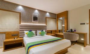 a hotel room with a bed and a desk at Treebo Trend Tiba in Bangalore