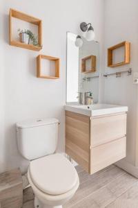 ein Badezimmer mit einem weißen WC und einem Waschbecken in der Unterkunft Harmonie 3 Chambres - spacieux in Saint-Étienne