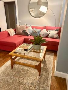 a living room with a red couch and a coffee table at Ground Floor Flat Close to city in Edinburgh