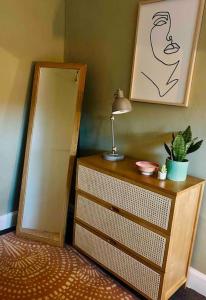 a dresser with a mirror and a lamp on it at Ground Floor Flat Close to city in Edinburgh