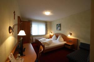 Habitación de hotel con cama y sofá en Hotel-Gasthof Hirschen en Blumberg