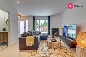 a living room with a couch and a fireplace at Le Blanc Bouleau de Portneuf / Private Hot tub in Pont-Rouge