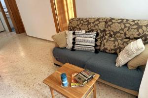 AZUL 2 bedroom apartment in Salou Tarragona في سالو: غرفة معيشة مع أريكة وطاولة قهوة