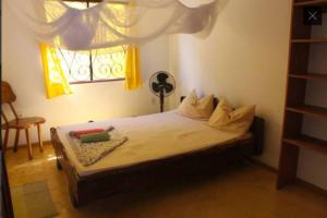 a bedroom with a bed and a window with yellow curtains at Apartamento com jardím e vista por rio, farol e mar in Itacaré