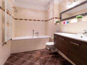 a bathroom with a tub and a toilet and a sink at Ferienwohnung Panoramablick in Altefähr +15 photos