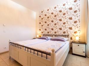 a bedroom with a bed with a floral wallpaper at Ferienwohnung Panoramablick in Altefähr