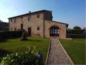 a large stone house with a grass yard at English Garden Cortona in Cortona