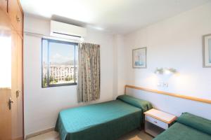 a bed room with two beds and a window at Apartamentos La Caseta - SABESA in Benidorm