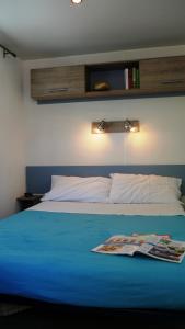 una camera da letto con un letto blu e una rivista sopra di Happy Camp mobile homes in Camping La Vecchia Torre a Gallipoli