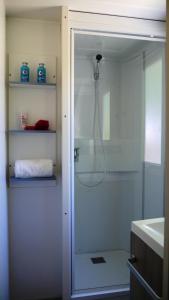 baño con ducha y puerta de cristal en Happy Camp mobile homes in Camping La Vecchia Torre, en Gallipoli