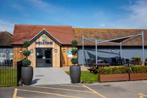 ein Gebäude mit einem Willkommensschild davor in der Unterkunft Camping Pods, Marlie Holiday Park in New Romney