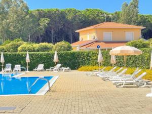 a swimming pool with lounge chairs and umbrellas next to a house at Villa Tiziana in Pizzo