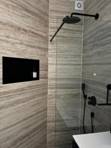 a bathroom with a shower with a television on the wall at B&B Urban Oasis in Amsterdam