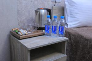 two bottles of water on a table next to a bed at Hayot Plaza Hotel Yotoqxonasi in Yunusobod