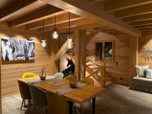 uma sala de jantar com uma mesa e cadeiras amarelas em Chalet Jardin Alpin Valberg em Péone