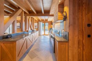 uma grande cozinha com paredes de madeira e balcões de madeira em Chalet Jardin Alpin Valberg em Péone